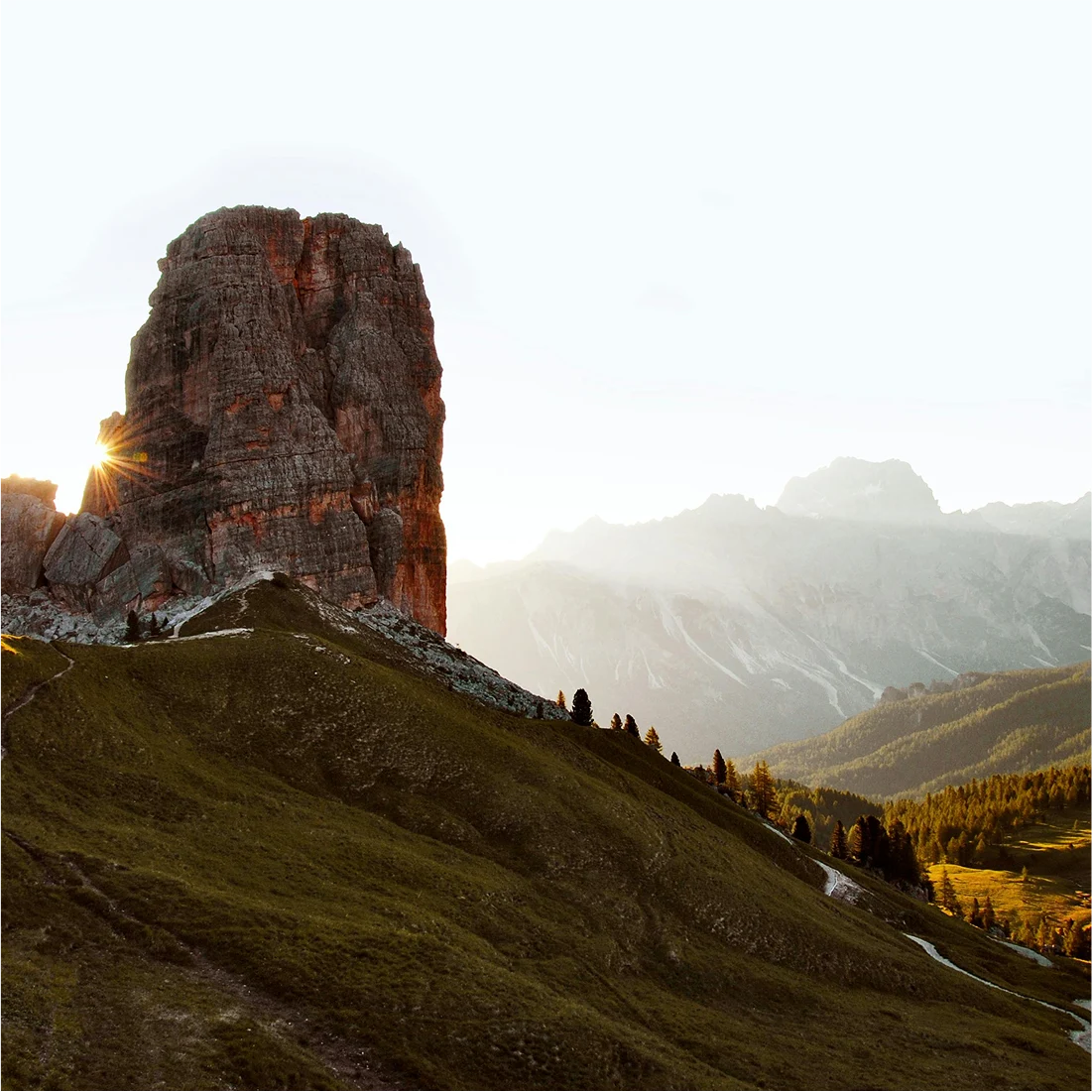 Sunlight peeking through a mountain peak in the Italian Dolomites at golden hour
